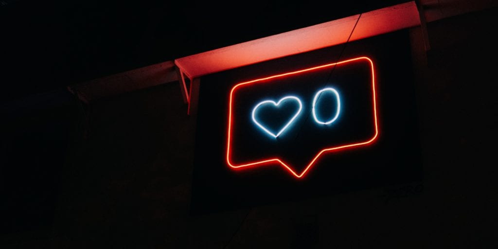 Neon light with a heart and zero likes.